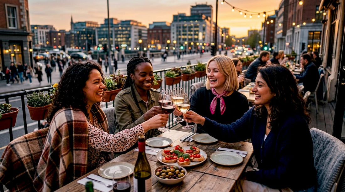 Women toasting with wine on rooftop terrace in evening