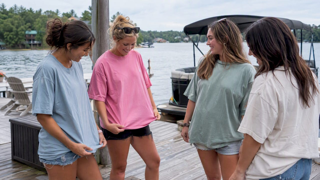Friends comparing shirts beside a lake